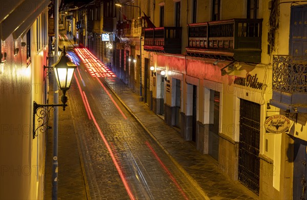 View from hotel balcony of cobblestone alley at night