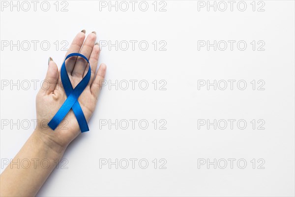 Crop hand with colon cancer ribbon