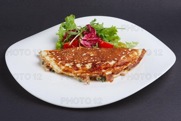 Omelet with ham and vegetables on a plate
