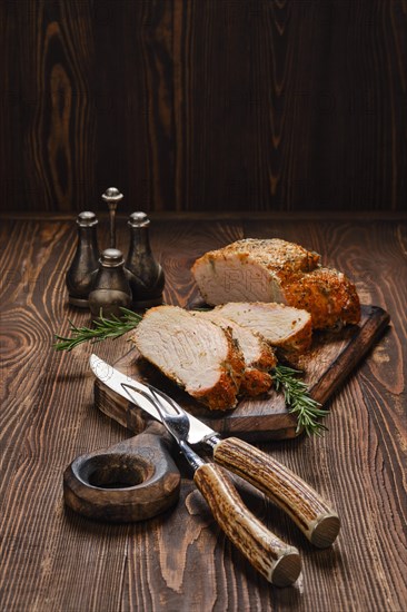 Pork strip loin baked in oven on wooden cutting board