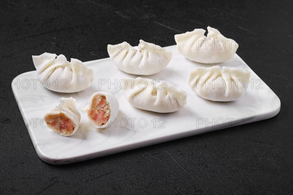 Frozen dumplings stuffed with liver and provencal herbs on marble serving plate