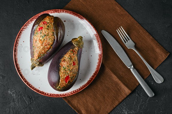 Semifinished eggplant stuffed with minced meat with spice on dark background