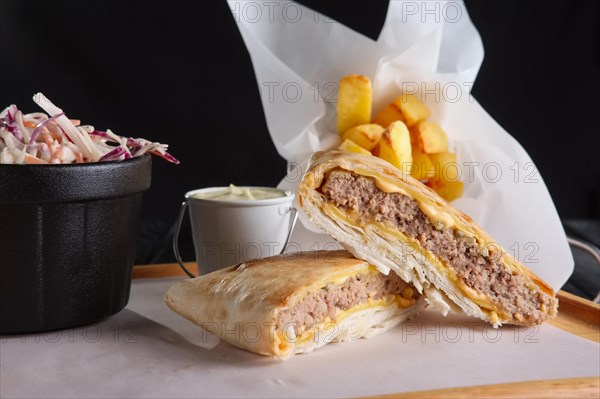 Beef cutlet with cheese rolled in pita with fried potato and red cabbage