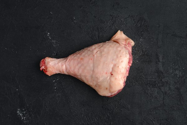 Raw turkey drumstick with skin on black background