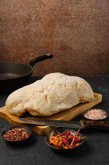 Lamb fat tail on kitchen table with salt and pepper