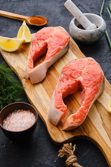 Raw fresh salmon steak on wooden cutting board