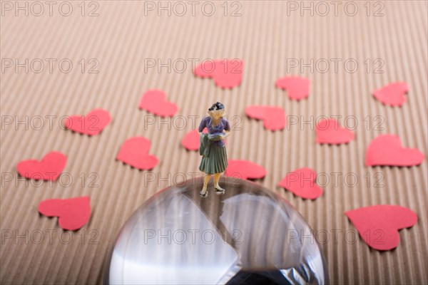 Woman figurine and Love concept with red paper hearts