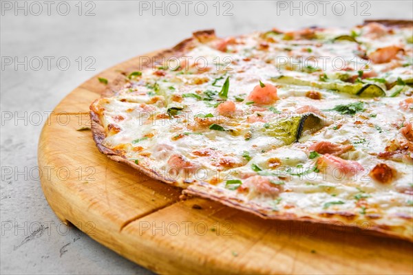 Thin-crust pizza dough with shrimps and zucchini