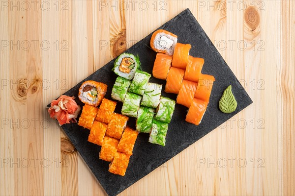 Set of rolls with wasabi and pickled ginger on stone serving board