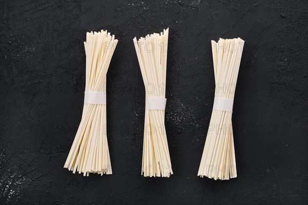 Dry Udon wheat noodles on black concrete background