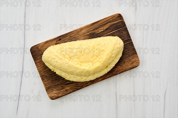 Top view of homemade cheese for grill on wooden cutting board