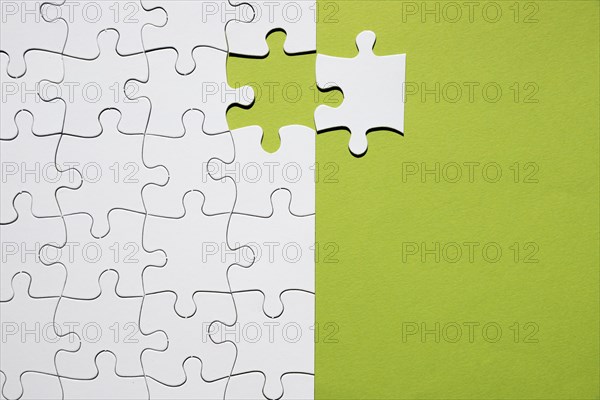 White puzzle piece separate with white puzzle grid green backdrop. Resolution and high quality beautiful photo