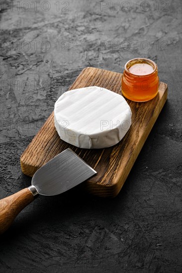 Piece of soft brie or camembert cheese on cutting board