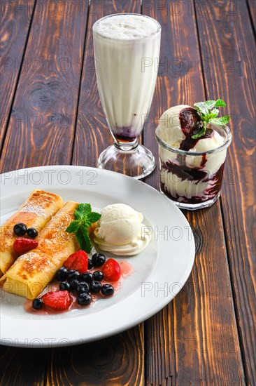 Plate with thin pancakes stuffed with curd and served with berry jam