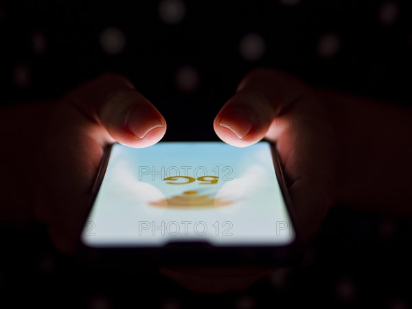 Person holding phone hands dark background