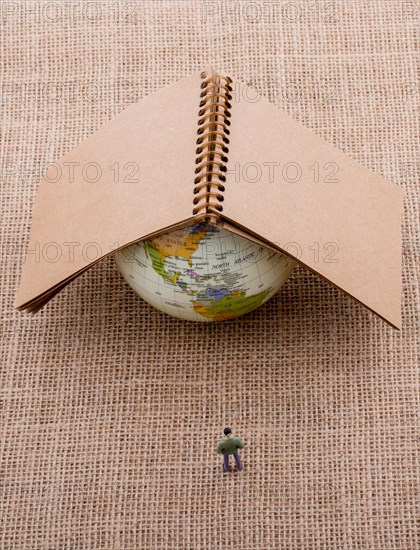 Figurine and globe with a notebook on the top of it