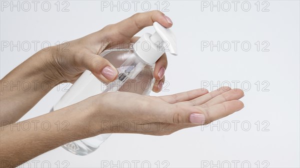 Person pouring liquid soap from bottle with copy space