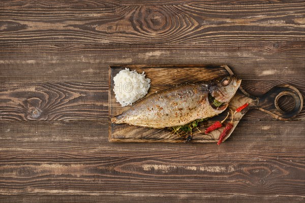 Baked sea yellow tailed mackerel on wooden cutting board