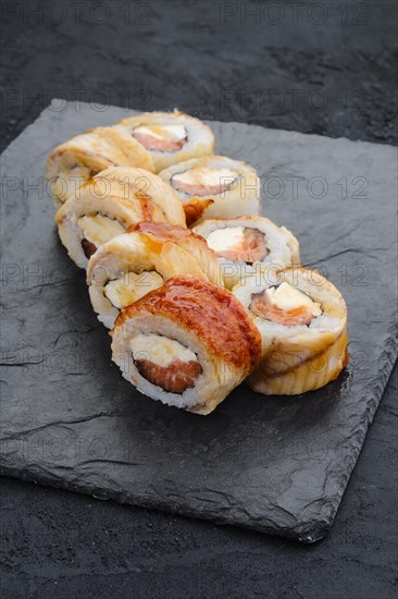 Rolls with eel and cream cheese on slate plate