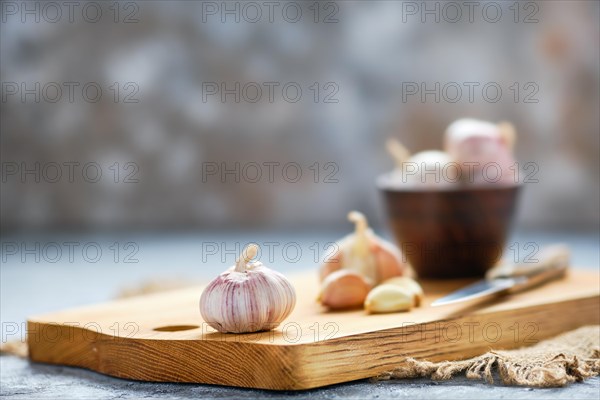 Garlic cloves and bulbs on wooden cutting board