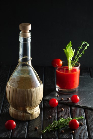 Rustic cocktail Bloody Mary with ingredient on wooden table