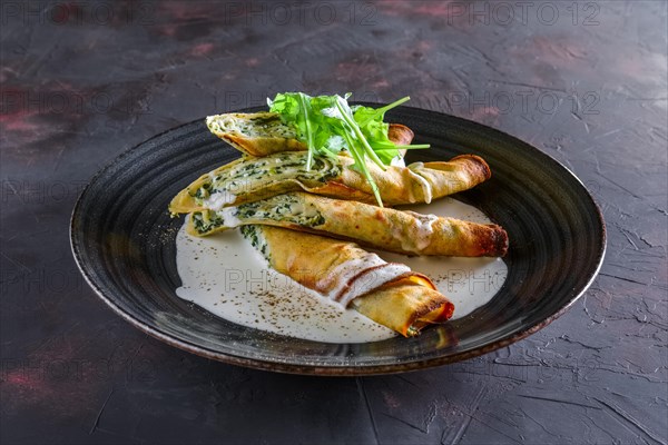 Thin pancakes stuffed with arugula and cheese