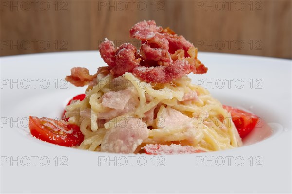 Plate with pasta served with bacon and ham