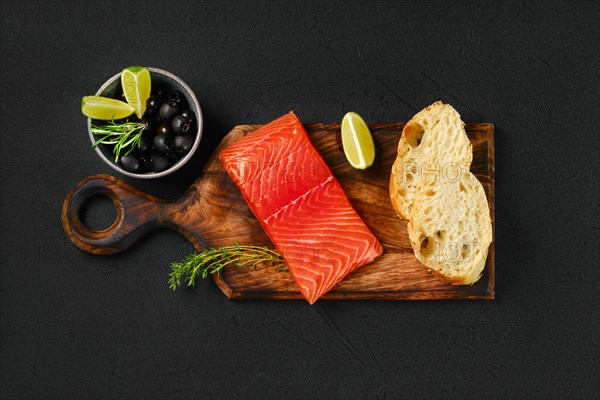 Top view of piece of fresh salmon steak with ciabatta and spicy herb sauce