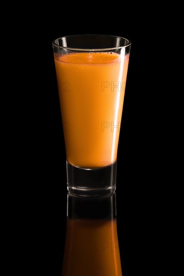 Glass of raspberry and strawberry cocktail isolated on black