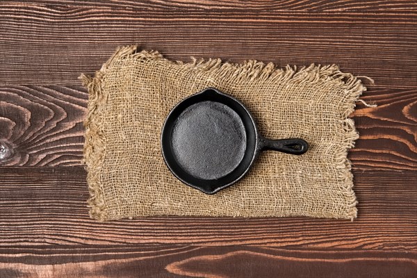 Empty mini cast-iron skillets on wooden table