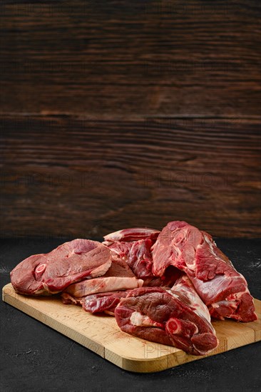 Assortment of raw fresh lamb meat on wooden tray