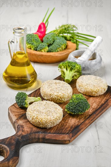 Semifinished homemade chicken cutlet with broccoli on a wooden serving board