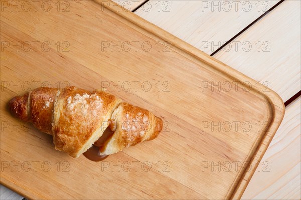 Top view of teared croissant with flowing out chocolate filling