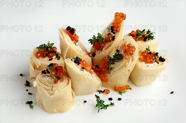 Close up view of pancakes with salmon and caviar on big white plate