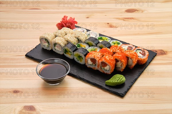 Big set of rolls with traditional garnish on wooden table