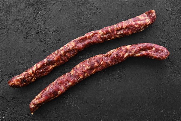 Top view of sun-dried pork sausage on black background