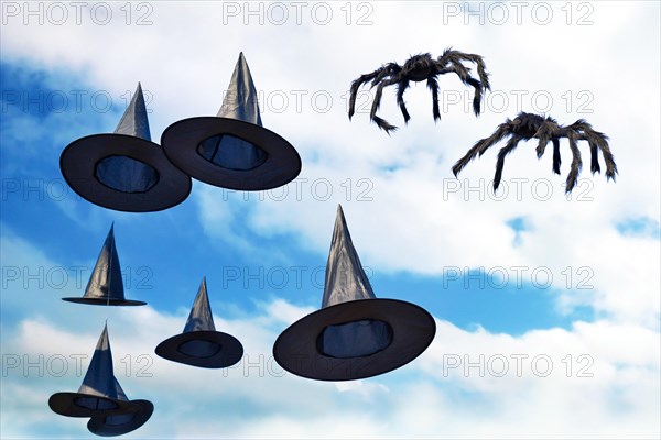 Halloween decoration witch hats and spiders hanging in sky