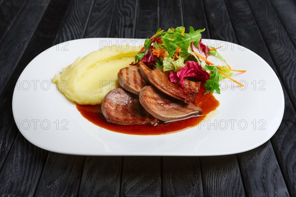 Beef tongue with mashed potato and salad with lingonberry sauce