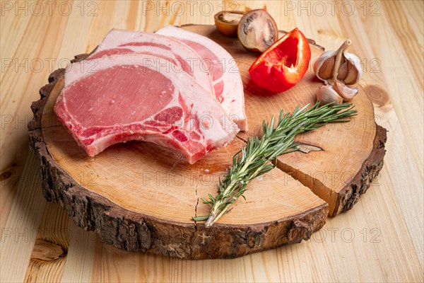 Raw fresh pork fillet steak on the bone on wooden cutting board