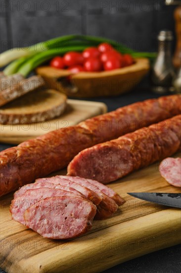 Closeup view of smoked lamb sausage rings on wooden cutting board on kitchen table
