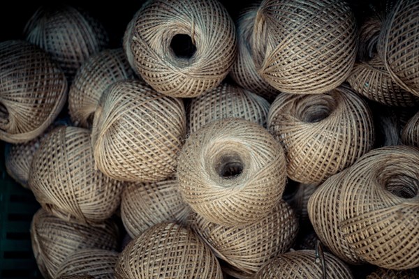 Plenty of spools or rolls of brown color linen string