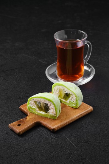 Sweet dessert mochi with kiwi cut on half and fruit tea