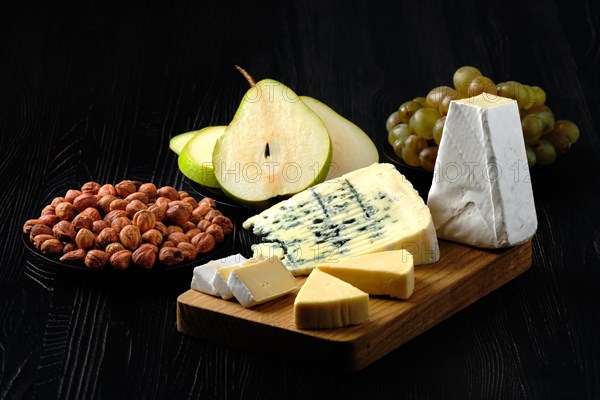 Low key photo of assortment of cheese and snack for wine