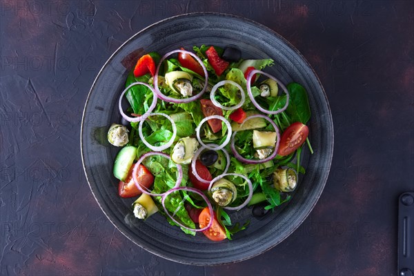 Fresh salad with zucchini stuffed with feta cheese with tomato