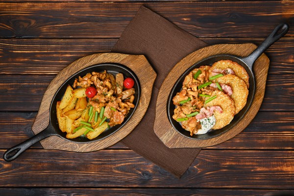 Top view of potato wedges with chanterelles and pork in cast iron skillet