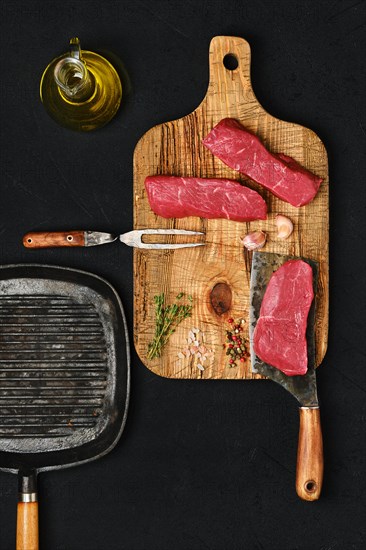 Top view of raw boneless beef strip steak on black background