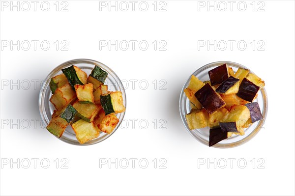 Fried square chips made of aubergine and zucchini in round glass plates isolated on white