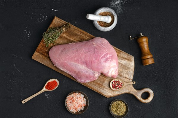 Raw fresh turkey boneless breast without skin on dark background