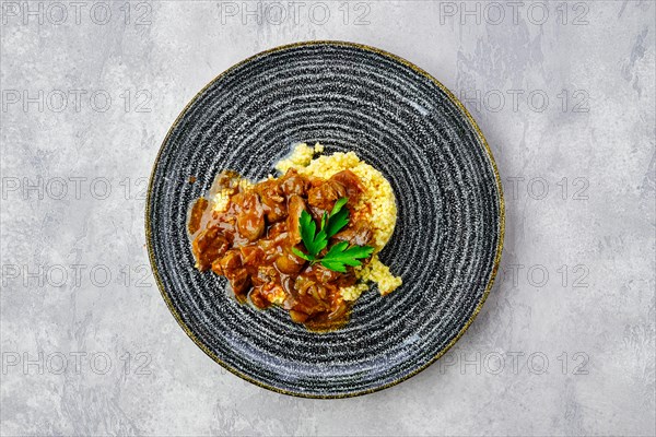 Top view of beef goulash with millet porridge and creamy sauce