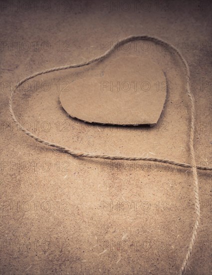 Thread off spool form a heart shape on brown background